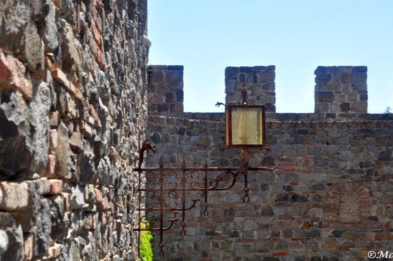 Castello Di Amorosa: каменная стена с ржавым фонарём
